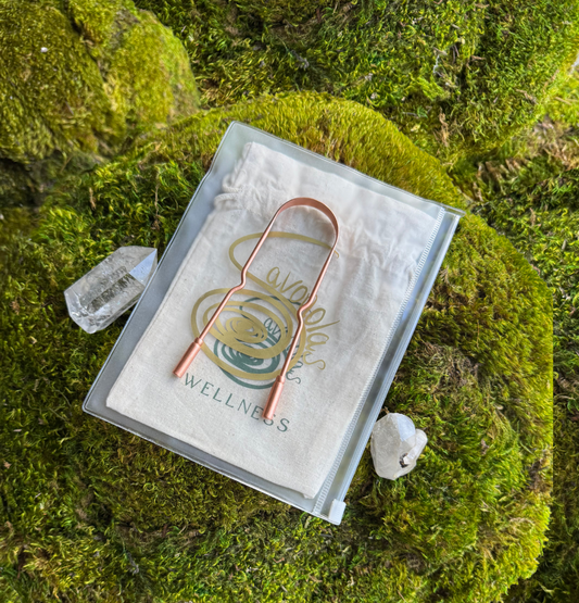 Savonolas copper tongue scraper and travel pouch displayed on green moss with crystals, natural wellness themed product flatlay.